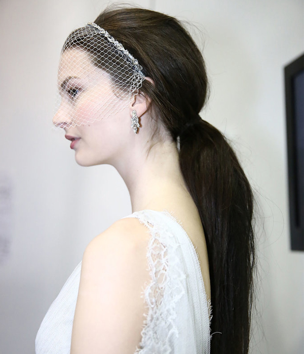 تسريحة الذيل حصان المزينة بطوق من التل المفرغ للعروس من Jenny Packham ربيع 2015