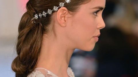 تسريحة كعكة الذيل حصان المزينة بتاج مرصع بالفصوص اللامعة للعروس من Oscar de la Renta ربيع 2015