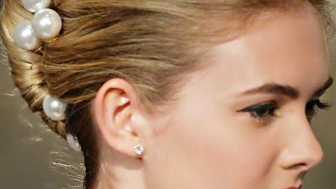 تسريحة الكعكة الفرنسية المزينة بفصوص اللؤلؤ للعروس من Carolina Herrera ربيع 2015