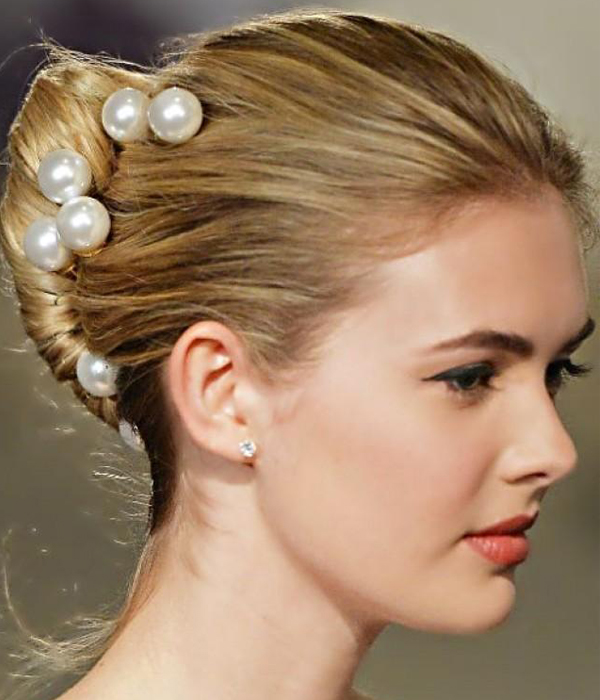تسريحة الكعكة الفرنسية المزينة بفصوص اللؤلؤ للعروس من Carolina Herrera ربيع 2015
