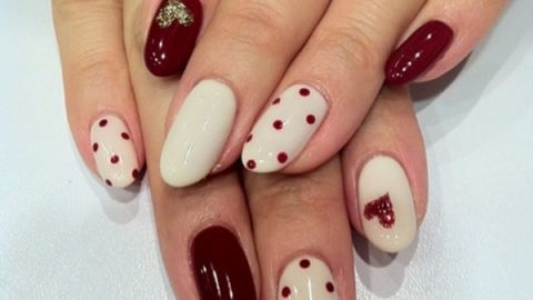 طلاء أظافر باللون البيج والأحمر الداكن مرسوم عليه قلوب لامعة لعيد الحب 2015